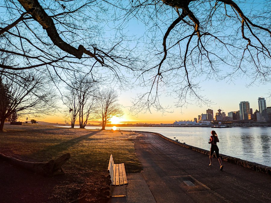 Someone running on the Stanley Park seawall at sunrise